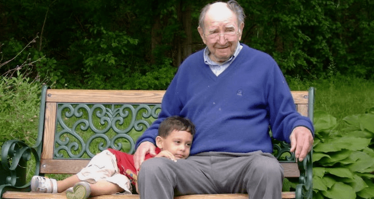 senior sitting on bench with grandson