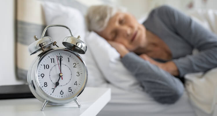Senior woman experiencing the health benefits of deep sleep.
