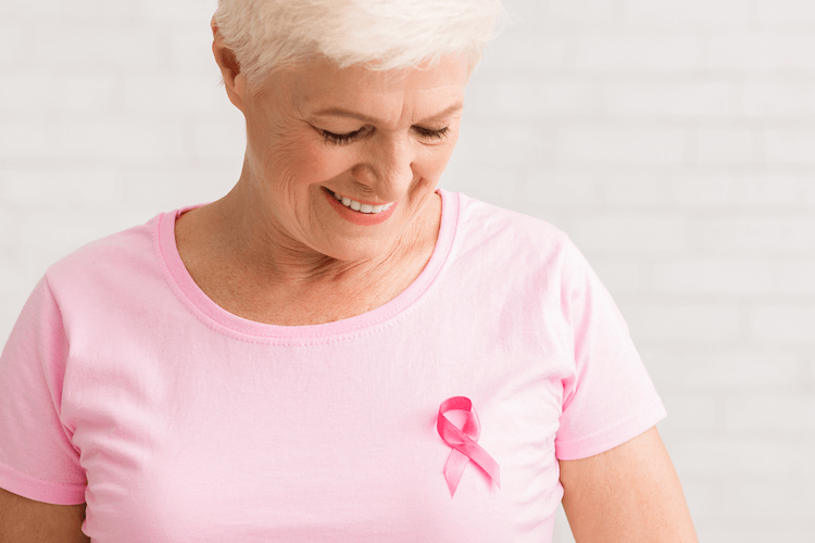 Woman wearing a pink ribbon in support of Breast Cancer Awareness Month.