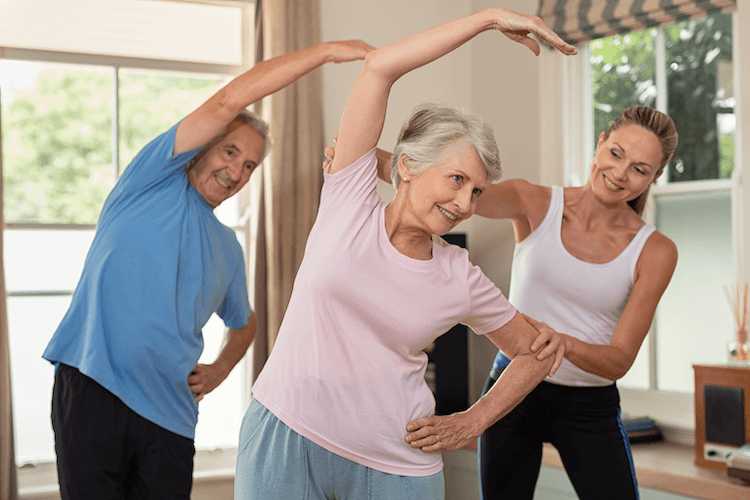 Senior couple engaging in an exercise program with a personal trainer.