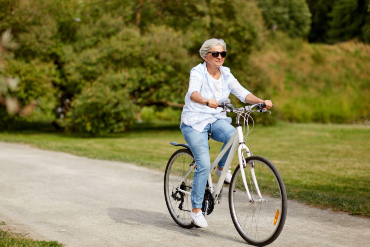 Senior woman enjoying a bike ride in the summer.