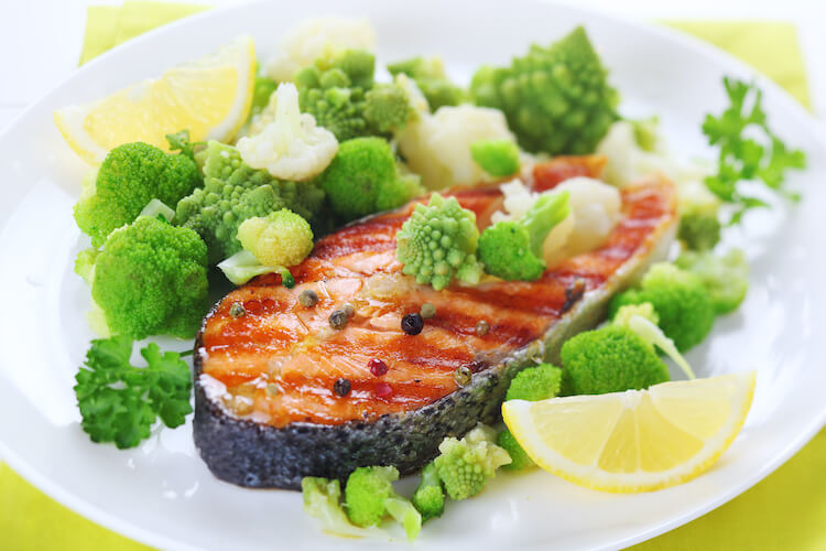 Grilled salmon on a plate with broccoli to represent a well-balanced diet.